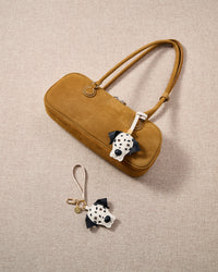 Close-up of handmade Dalmatian Luxe leather bag charm — hand-stitched visible edges on French Alran goatskin, amber eyes, raised leather nose. STICKYZOO.