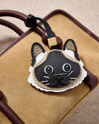 Siamese charm close on a tan suede top-handle bag, side angle — loved by thousands of Siamese people. Real French leather, 3 days by hand.