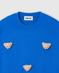 Close-up of plush bear face appliques on blue 230gsm cotton showing fuzzy stuffed texture