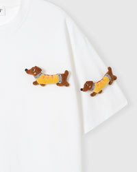 Detail of plush dachshunds on body and sleeve of STICKYZOO white Dachshund Parade T-Shirt