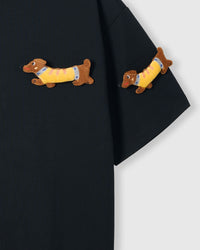 Detail of plush dachshunds on body and sleeve of STICKYZOO black Dachshund Parade T-Shirt