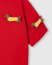 Detail of plush dachshunds on body and sleeve of STICKYZOO red Dachshund Parade T-Shirt