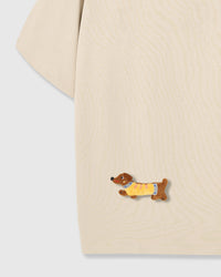 Detail of plush dachshund on body of STICKYZOO cream Dachshund Parade T-Shirt showing hand-stitched 3D detail
