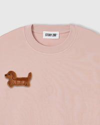 Close-up of hand-stitched plush dachshund on pink 230gsm cotton showing dimensional texture