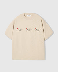 STICKYZOO Spotty Dash Trio T-Shirt in cream — three hand-stitched plush spotted dachshund appliqués with red berets