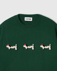 Three plush spotted dachshund appliqués with red beret detail on STICKYZOO green oversized t-shirt