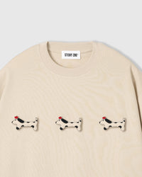 Three plush spotted dachshund appliqués with red beret detail on STICKYZOO cream oversized t-shirt