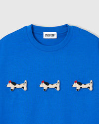 Three plush spotted dachshund appliqués with red beret detail on STICKYZOO blue oversized t-shirt