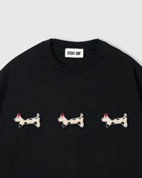 Three plush spotted dachshund appliqués with red beret detail on STICKYZOO black oversized t-shirt