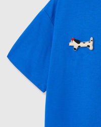 Single plush spotted dachshund appliqué with red beret — hand-stitched on blue 230gsm cotton