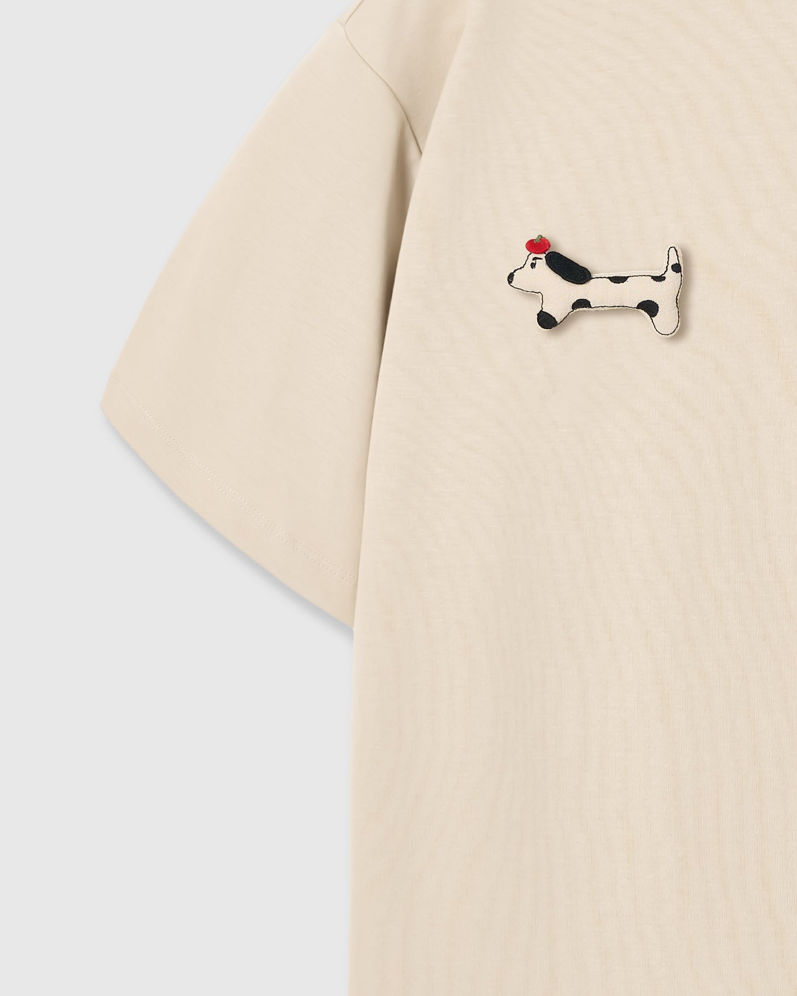 Single plush spotted dachshund appliqué with red beret — hand-stitched on cream 230gsm cotton