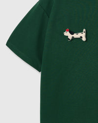 Single plush spotted dachshund appliqué with red beret — hand-stitched on green 230gsm cotton