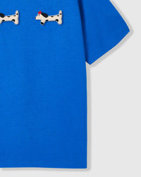 Spotted dachshund plush appliqué detail showing hand-stitched craft on STICKYZOO blue t-shirt