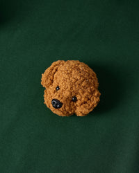 Macro close-up of single plush poodle face on green 230gsm cotton showing curly 3D texture