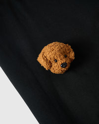 Macro close-up of single plush poodle face on black 230gsm cotton showing curly 3D texture