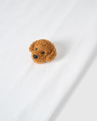 Macro close-up of single plush poodle face on white 230gsm cotton showing curly 3D texture