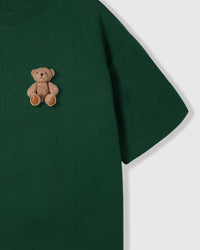 Close-up of plush teddy bear on forest green STICKYZOO t-shirt showing 3D texture and embroidered features