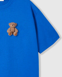 Close-up of second plush teddy bear near hem on blue cotton