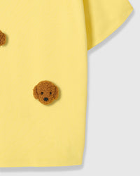 Detail of lower body area on lemon Poodle Parade T-Shirt showing plush poodle appliques