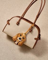 Cocker Spaniel leather bag charm with leather strap on a cream canvas handbag — French Alran goatskin and suede from a tannery founded in 1903 in Tarn, France. STICKYZOO collectible.