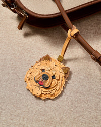 Close-up of handmade Chow Chow leather bag charm — fluffy mane built from individually hand-cut feather panels in French Alran leather and suede. STICKYZOO collectible.