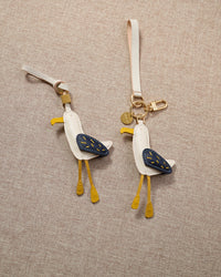 Close-up of the seagull — hand-stitched black wing feathers, yellow beak, dangling yellow leather legs. Every panel by hand.