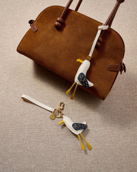 Seagull charm styled on a bag, front — a small, specific piece that turns a simple bag into a personal one.
