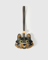 Maison Tabby cat charm handmade from French Alran genuine goatskin — dark olive body, warm tan cheek markings, yellow eyes, dark nose, olive-grey leather strap. Three days by hand. Arrives in luxury gift packaging. Designed in Amsterdam.