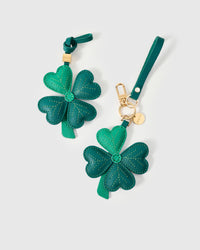 STICKYZOO Lucky Clover Charm clipped to a handbag — handmade French Alran goatskin in emerald green. 3-day artisan build.