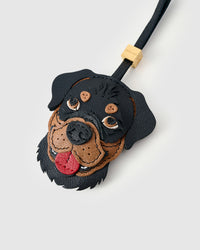 Close-up of handmade Rottweiler leather bag charm — hand-stitched visible edges on French Alran goatskin, hand-layered black-and-tan markings, 18K gold-plated cube hardware. STICKYZOO collectible.