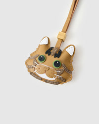 Tight close-up of the Forest Tabby face — green eyes in real leather, tabby stripes hand-stitched across the forehead, white chin, pink nose. Every panel by hand.