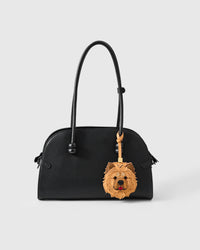 Handmade Chow Chow leather bag charm clipped to a black leather handbag — French Alran leather and suede, 18K gold-plated hardware. STICKYZOO collectible.