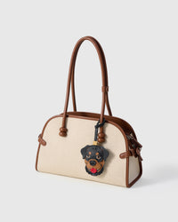 Handmade Rottweiler leather bag charm on a cream canvas handbag — French Alran goatskin from a tannery founded in 1903 in Tarn, France. STICKYZOO collectible.