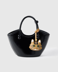 Forest Tabby charm styled on a glossy black bucket bag, front — the small piece that turns a simple bag into a personal one.