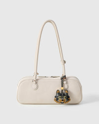 Maison Tabby styled on an ivory pebbled-leather bag, front — real French leather, made to be carried on the bag that sees every day.