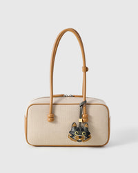 Maison Tabby styled on a cream canvas-and-tan top-handle bag, front — a small, specific piece that turns a simple bag into a personal one.