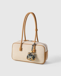 Maison Tabby on a cream canvas-and-tan top-handle bag, side angle — loved by thousands of cat lovers. Real French leather, 3 days by hand.