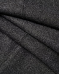 Extreme close-up of black wool-blend fabric texture showing matte finish and seam detail