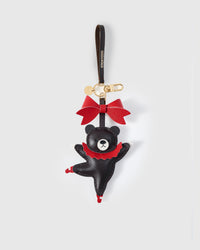 Close-up of the Parisian Bear — red leather tutu, red ballet shoes, black body mid-dance, red bow. Every panel by hand.