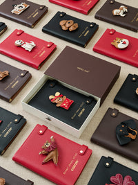 STICKYZOO notebook collection flat lay showing multiple designs in gift packaging with handmade French Alran leather charms