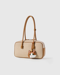 Patchwork cat charm on a cream canvas-and-tan top-handle bag, side angle — Real French leather, 3 days by hand.