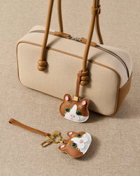 Patchwork cat — both editions alongside a cream canvas top-handle bag. Real French leather, 3 days by hand.