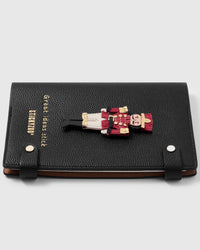 French Alran leather nutcracker charm detail showing hand-cut and hand-stitched layers with engraved gold-plated hardware