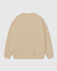 Back view of cream cotton sweatshirt showing ribbed cuffs and relaxed oversized fit