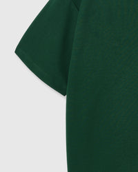 Model wearing STICKYZOO Hug-Me Bear T-Shirt in forest green showing dropped shoulders