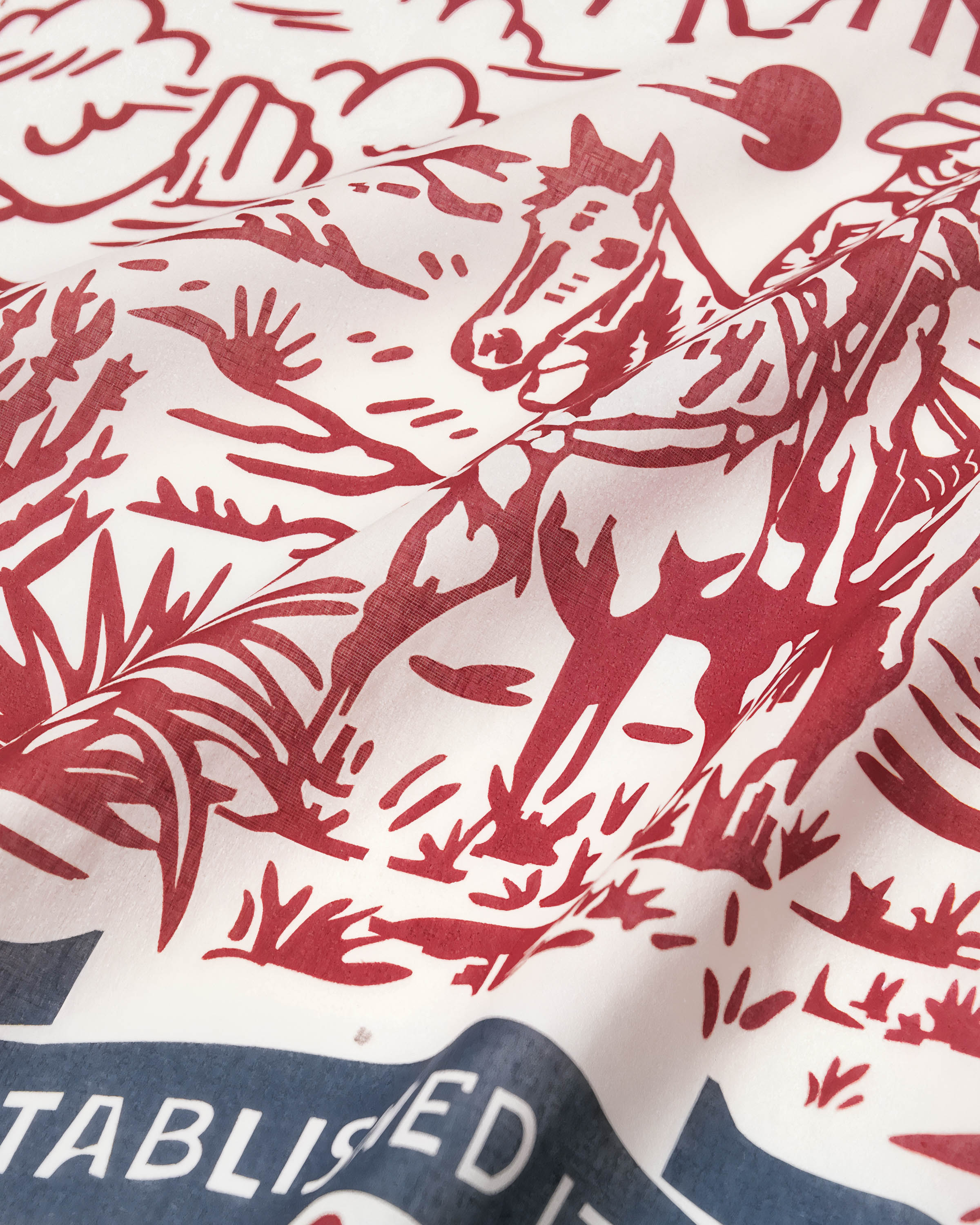 Hand-illustrated cowboy on horseback printed in burgundy archival ink on the STICKYZOO western ranch silk scarf
```