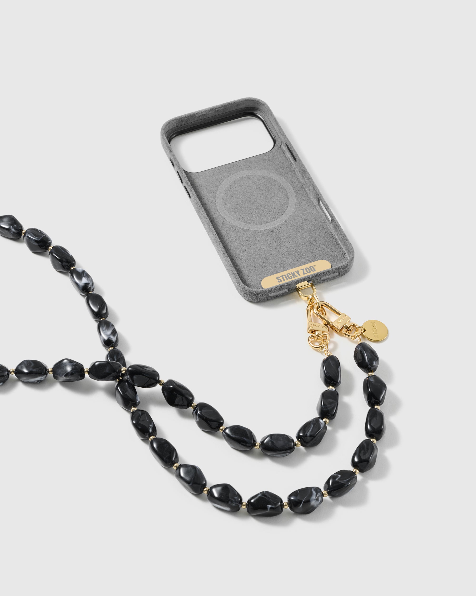Full phone worn on the long black beaded cross-body strap in a studio setting