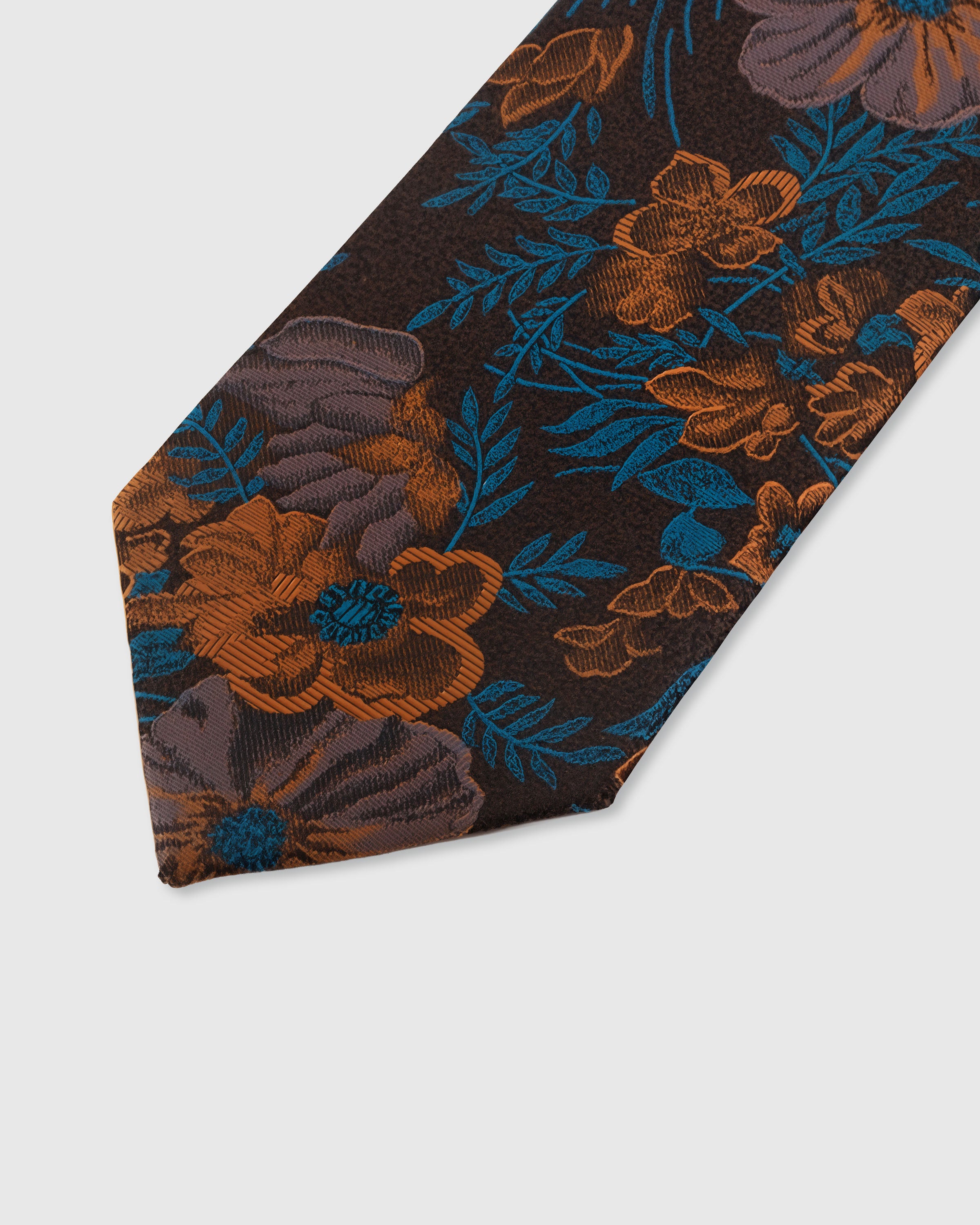 STICKYZOO UMBER TROPICANA TIE — hand-embroidered detail showing teal and copper tropical floral blooms, stitched not printed