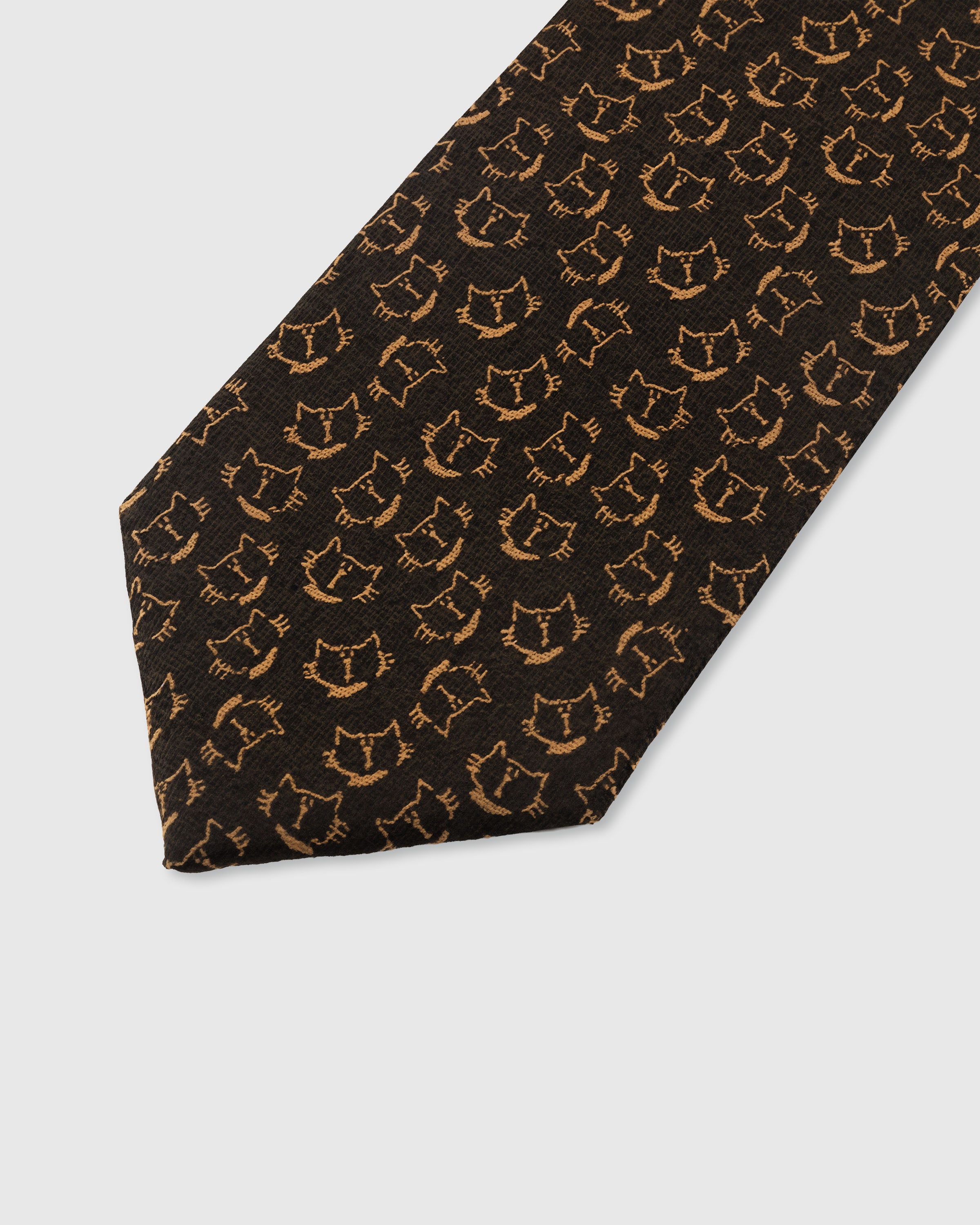 STICKYZOO NOIR CAT TIE — hand-embroidered detail showing copper-gold smiling cat face motifs, stitched not printed