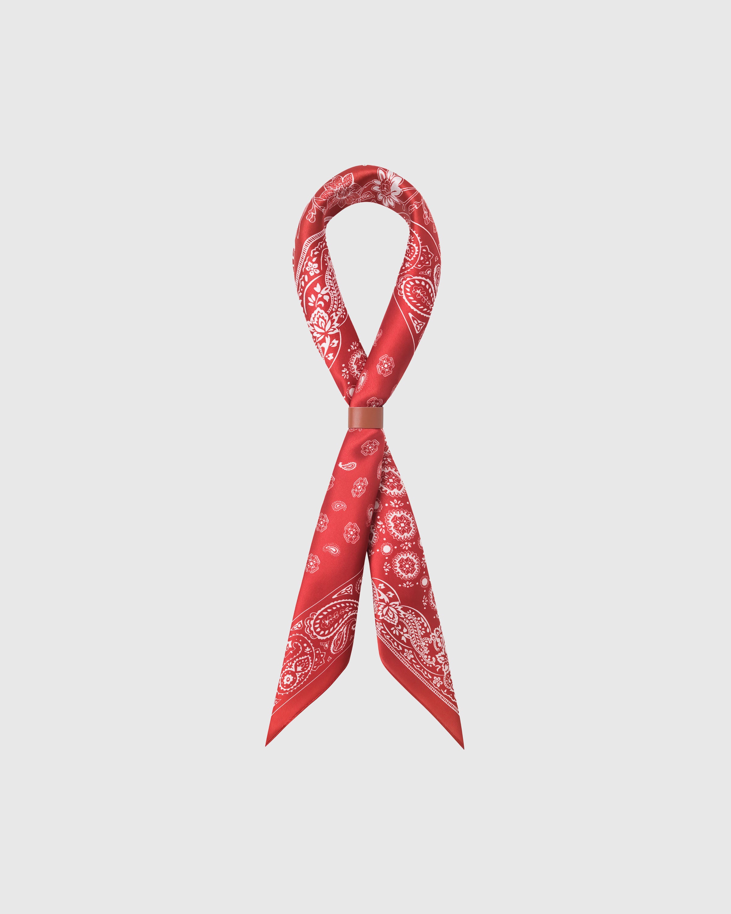 STICKYZOO rouge bandana silk scarf looped through a leather cuff showing the four-panel print